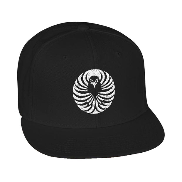 Snapback cap with an embroidered emblem representing a raven, front